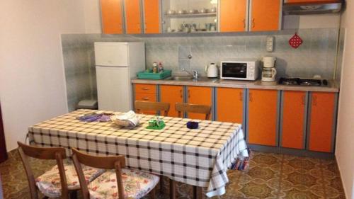 a kitchen with a table with chairs and a refrigerator at Villa Bencun in Medulin