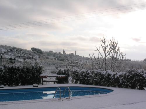 a swimming pool covered in snow with a city in the background at Agriturismo Il Piastrino in Vinci