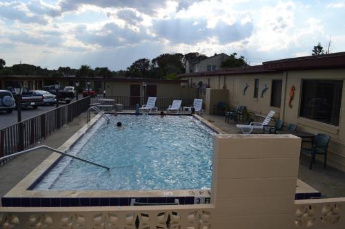 una grande piscina con sedie in un parcheggio di Atlantic Economy Inn a Daytona Beach