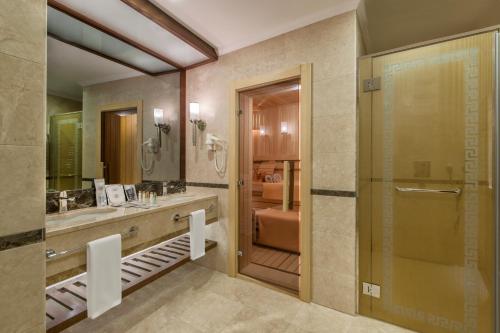 a bathroom with a shower and a sink and a mirror at Akrones Thermal Spa Convention in Afyon