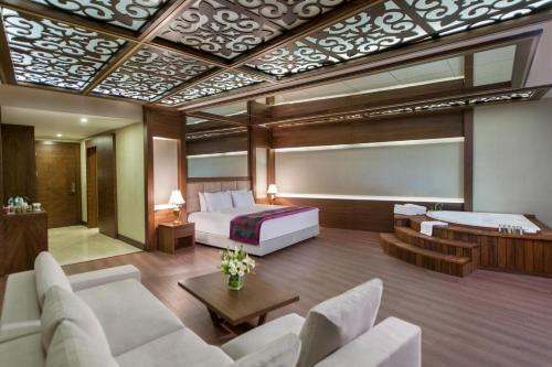 アフィヨンにあるAkrones Thermal SPA Convention Sport Hotelのベッドとリビングルームのある寝室