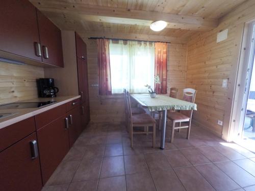 eine Küche mit einem Tisch und Stühlen in einer Hütte in der Unterkunft Ferienhaus Blasge in Bodensdorf