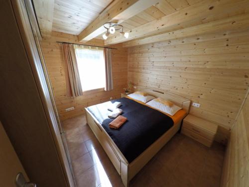 ein kleines Zimmer mit einem Bett in einer Holzhütte in der Unterkunft Ferienhaus Blasge in Bodensdorf