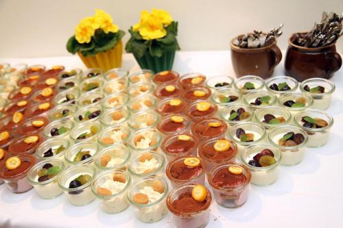 a table topped with lots of small cups of desserts at Altsächsischer Gasthof Kleines Vorwerk in Sayda