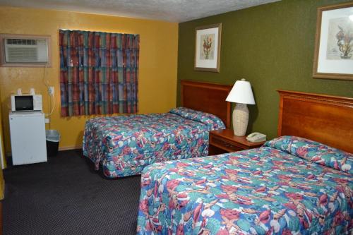 una camera d'albergo con due letti e una lampada di Atlantic Economy Inn a Daytona Beach