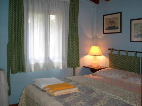 a bedroom with a bed with a window and a lamp at Le Giunchete in Cavriglia