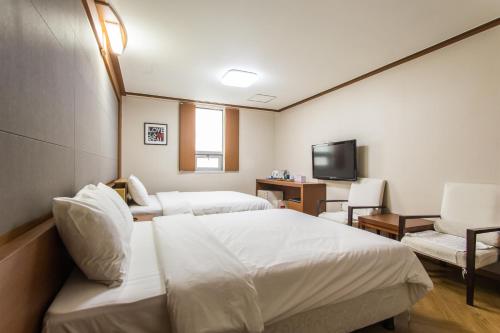 a hotel room with two beds and a flat screen tv at Incheon Airtel in Incheon