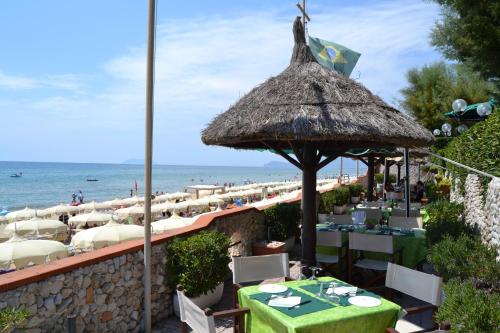 a restaurant on the beach with tables and chairs at Hotel La Nave in Sperlonga