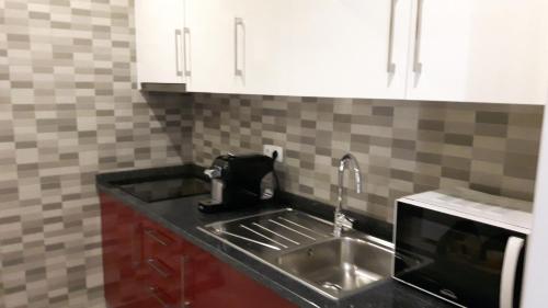 una cucina con lavello e microonde di Rocha Apartment a Portimão