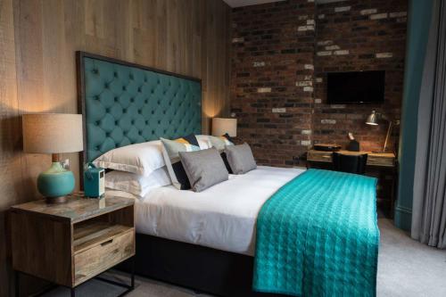 a bedroom with a large bed with a blue headboard at The Driftwood Bexhill in Bexhill