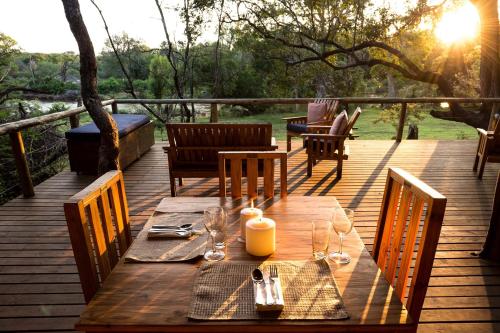 a wooden table with wine glasses on a deck at Rukiya Safari Camp in Hoedspruit