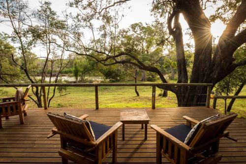 two chairs and a table on a wooden deck at Rukiya Safari Camp in Hoedspruit