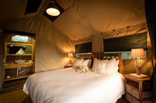 a bedroom with a large bed in a tent at Rukiya Safari Camp in Hoedspruit