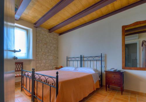 a bedroom with a bed and a mirror and a window at Agriturismo Casa Rossi di Paolo Rossi in Numana