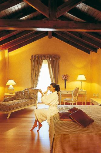 a woman sitting on a bed in a room at Siora Vittoria Boutique Hotel in Corfu Town
