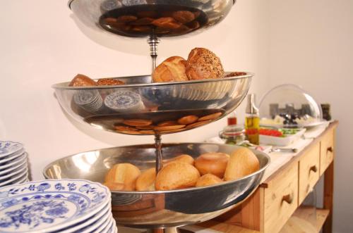 two bowls of bread on a shelf with plates at Georg Rass Gästehaus in Norderney