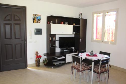 a dining room with a table and a television at Casa Vacanze Roccella Beach in Campofelice di Roccella