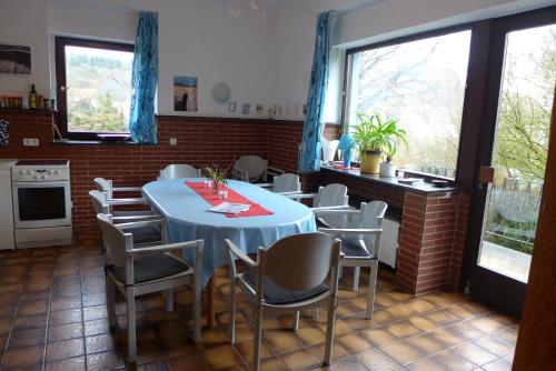 comedor con mesa azul y sillas en O11- Großzügige Fewo im Künstlerhaus, en Lichtenfels-Sachsenberg