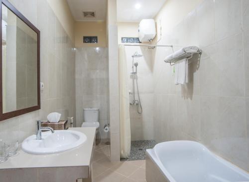 a bathroom with a sink and a toilet and a mirror at Astana Made Villas in Sanur