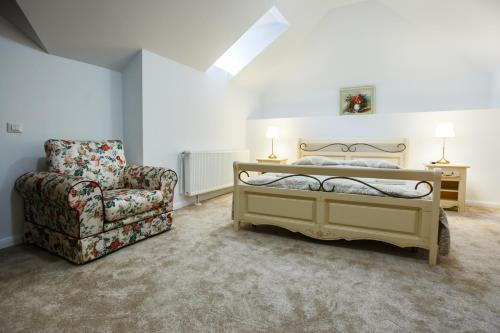 a bedroom with a bed and a chair at Maisonette Apartments in Cîmpulung