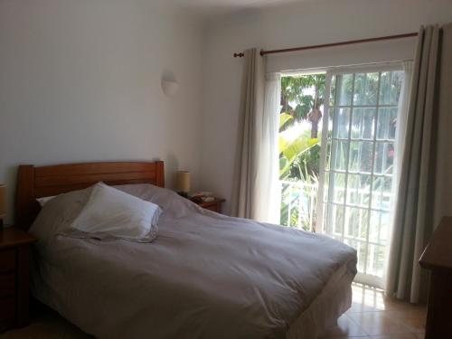 a bedroom with a bed and a large window at Praia da Luz Apartments in Luz