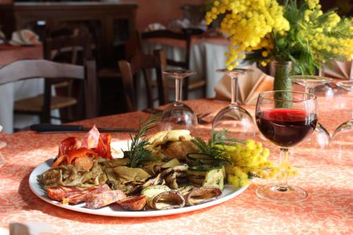 a plate of food on a table with wine glasses at Azienda Agrituristica Le Puzelle in Santa Severina