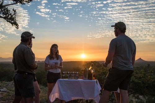 a group of people standing around a table with wine glasses at Rukiya Safari Camp in Hoedspruit