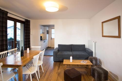 a living room with a couch and a table at Chalet Hotel Régina in Les Gets