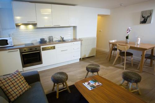 a kitchen and a living room with a table and chairs at Chalet Hotel Régina in Les Gets