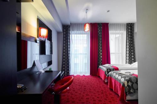 Pokój hotelowy z 2 łóżkami i biurkiem w obiekcie Hotel Zimowit w mieście Rzeszów