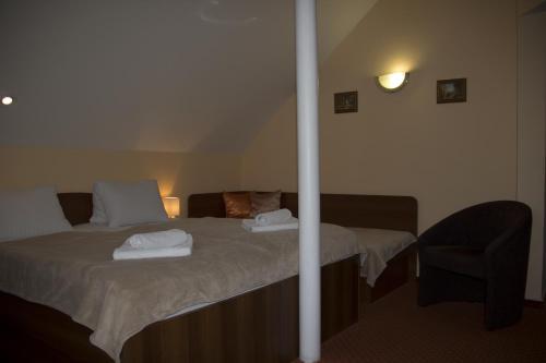 a bedroom with a bed with two towels on it at Penzion Oaza in Luhačovice