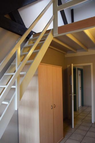 a staircase in a room with a wooden door at Condo Gardens Antwerp in Antwerp