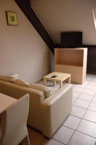 a living room with a couch and a table at Condo Gardens Antwerp in Antwerp