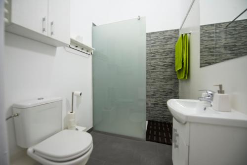 a white bathroom with a toilet and a sink at Apartament Maria in Timişoara