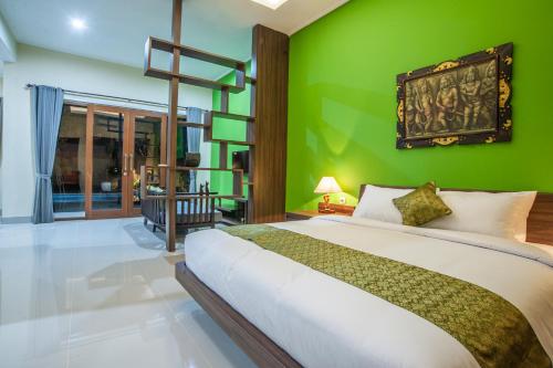 a bedroom with green walls and a large bed at Astana Made Villas in Sanur
