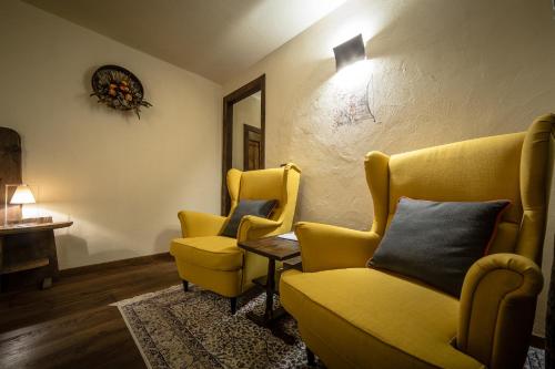 a living room with two yellow chairs and a table at Domus Antica Aosta in Aosta