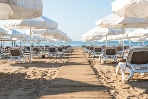 a row of chairs and umbrellas on the beach at Barut B Suites in Side