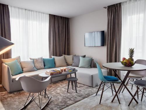 a living room with a couch and a table and chairs at VISIONAPARTMENTS Militärstrasse - contactless check-in in Zürich