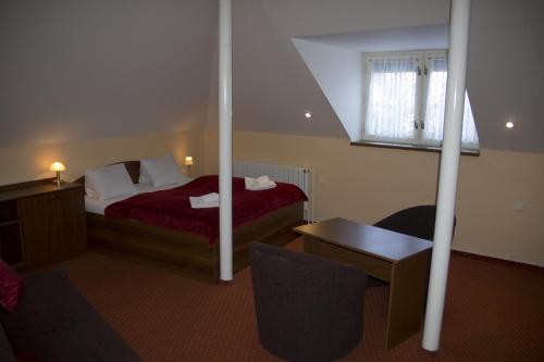 a hotel room with a bed and a desk and a chair at Penzion Oaza in Luhačovice