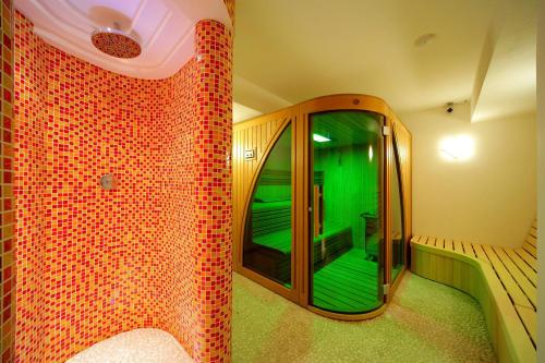 een kamer met een spiegel en een inloopdouche bij Hotel Lesana in Špindlerův Mlýn