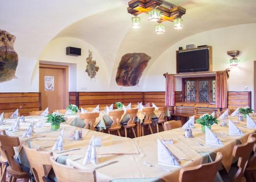 una grande stanza con tavoli, sedie e una TV di Gasthof Mandorfer a Hörsching