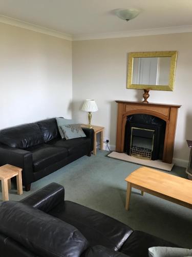 a living room with a couch and a fireplace at The Shorehouse in Brodick