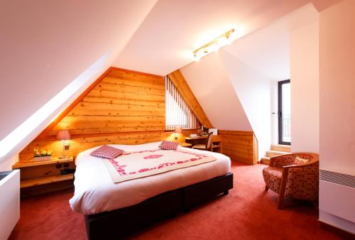 Le Rosenmeer - Hotel Restaurant, au coeur de la route des vins d'Alsace في Rosheim: غرفة نوم بسرير كبير في العلية