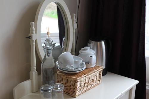 a table with a mirror and a basket with dishes and a bottle at Rhydspence in Hay-on-Wye