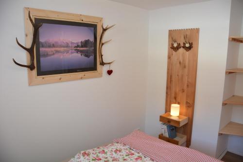 a bedroom with a tv on the wall with a bed at Apartment Almröserl Edelweiss in Gosau