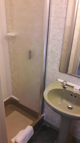 a bathroom with a sink, toilet and shower at Mornington Hotel in Saint Helier Jersey