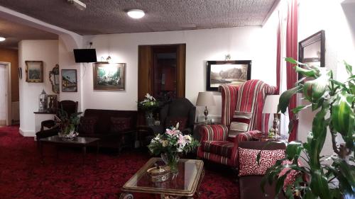 a living room with two chairs and a table at Mornington Hotel in Saint Helier Jersey