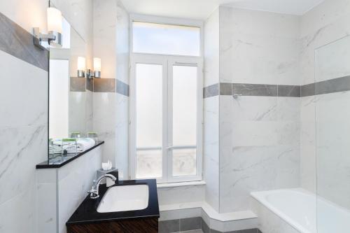 فندق ذا جاي باي هابي كولتشر في نيس: حمام أبيض مع حوض ونافذة