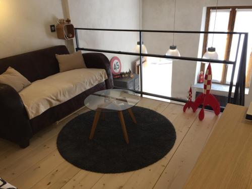a living room with a couch and a glass table at La Galisesagnoise in Briançonnet