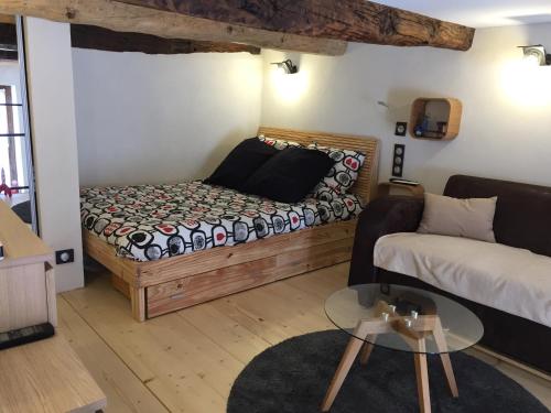 a room with a bed and a couch and a table at La Galisesagnoise in Briançonnet